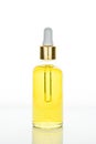 Trendy dropper glass bottle with yellow oil on white background