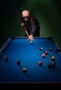 Trendy dude playing a game of pool in a nightclub Royalty Free Stock Photo