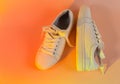 Trendy fashion white sneakers on abstract bright background. Neon lights on casual shoes. Orange and red gradient light. Royalty Free Stock Photo