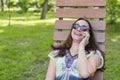 Trendy fashionable beautiful woman calling talking on her cellphone in the park. Beautiful young woman talking on cell phone while Royalty Free Stock Photo