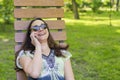 Trendy fashionable beautiful woman calling talking on her cellphone in the park. Beautiful young woman talking on cell phone while Royalty Free Stock Photo