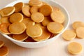 Trendy food - pancake cereal. Heap of mini cereal pancakes in bowl on bright background