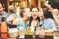 Trendy friends drinking cocktails and wine in hostel bar at happy hour - Young students having party in pub restaurant - Fun and Royalty Free Stock Photo