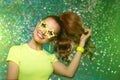 Trendy girl with bright green neon accessories. Model in a disco nightclub. Woman at a theme party in the rays of light