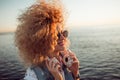 Trendy girl with large headphones and sunglasses on a city walk, close up Royalty Free Stock Photo