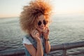 Trendy girl with large headphones and sunglasses on a city walk, close up. Royalty Free Stock Photo