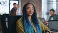 Trendy girl manager posing in office with working team at backdrop close up. Royalty Free Stock Photo