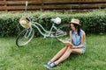 Trendy girl in straw hat reading Royalty Free Stock Photo