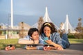 Trendy couple browsing web on smartphone outdoors using 4g internet connection lying on longboard Royalty Free Stock Photo