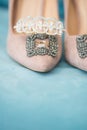 Trendy, graceful suede high heel shoes and wedding rings and jewelery in a blue suede chair. Wedding details.