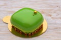 Trendy green mousse cake with mirror glaze decorated. wooden background Royalty Free Stock Photo