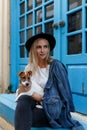 Trendy Hipster blonde Girl with her Dog on Urban Background. Modern Youth Lifestyle Concept Royalty Free Stock Photo