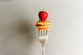 Trendy home breakfast with tiny cereal pancakes and fresh strawberries on the fork. Royalty Free Stock Photo