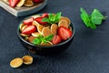 Trendy home breakfast with tiny pancakes mini pancakes with strawberries and mint in a bowl cup on a dark background. Royalty Free Stock Photo