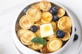 Trendy homemade breakfast, pancake cereal, mini pancakes with berries