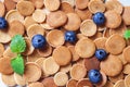 Trendy homemade breakfast, pancake cereal, mini pancakes on light plate on pink concrete background