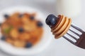 Trendy homemade breakfast, pancake cereal, mini pancakes on white plate on white concrete background with spoon and blueberry, Royalty Free Stock Photo