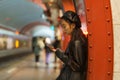 Trendy japanese girl suffer from smartphone and social media addiction miss train at subway platform Royalty Free Stock Photo
