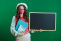 Trendy learner woman showing blank board on green