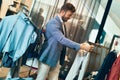 Trendy man in menswear store choosing pantaloons Royalty Free Stock Photo