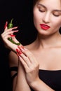 Trendy manicure and red lips with green chili pepper. Royalty Free Stock Photo