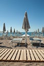 Trendy mediterranean beach with sun umbrellas and sunbeds with blue sea and blue sky on background. Perfect summer Royalty Free Stock Photo