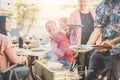 Trendy man cooking and serving meat at barbecue dinner outdoor - Chef grilling food for family friends at bbq meal outside -