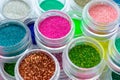 Trendy multicolored glitter in jars. Shimmer, sparkle for makeup, manicure. Shiny powder, pigments. Cosmetic products. Royalty Free Stock Photo