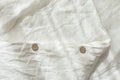 Trendy organic natural linen bedclothes with wooden buttons closeup. Bedding