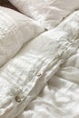 Trendy organic natural linen bedclothes with wooden buttons closeup. Bedding