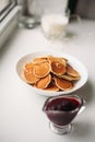 Trendy pancake cereal meal. Tiny baked pancakes with jam. Breakfast food. Table top view