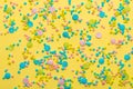 Trendy pattern of colorful round sprinkles over yellow background, decoration for festive Valentines day, birthday, holiday and