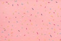 pattern of colorful sprinkles for background of design banner, poster, flyer, card, postcard, cover, brochure over pink