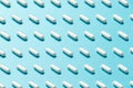 Trendy pattern made with Pharmaceutical medicine pills, tablets and capsules on bright light blue background Royalty Free Stock Photo