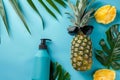 Trendy pineapple with sunglasses and sunblock on soft colored background for text