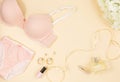 Trendy pink modern lady bra and silk panty, perfume. Fashionable cotton lingerie, woman underwear. Lace panties and bra on beige