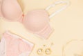 Trendy pink modern lady bra and silk panty, perfume. Fashionable cotton lingerie, woman underwear. Lace panties and bra on beige