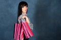 Trendy pretty girl, brunette with shopping bags for the monochrome blue, trendy shabby background, shopping theme