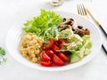 Vegan Buddha bowl with lentil, avocado, mushrooms, lettuce, tomatoes and chia seeds.