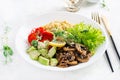 Vegan Buddha bowl with lentil, avocado, mushrooms, lettuce, tomatoes and chia seeds.