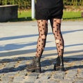 Trendy screaming girl wearing holey tights and shabby boots on big city street. Royalty Free Stock Photo