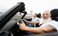 Trendy senior couple having fun in convertible car during summer vacation - Focus on man face Royalty Free Stock Photo