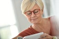 Trendy senior woman wearing eyeglasses and using smartphone Royalty Free Stock Photo