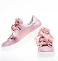 Trendy sneakers concept. Footwear for girls and women decorated with pearl beads. Pair of pale pink female sneakers with