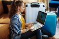 Trendy solo traveller woman booking tickets on laptop