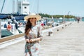 Trendy solo traveller woman in floral dress on pier