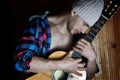 Trendy sporty hipster man with strong hands hold and dance with old guitar on wood background