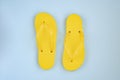 Trendy sunlight Summer composition. Beach flip-flops on a bright light blue background.