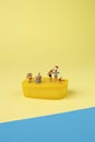 Trendy sunlight Summer scene made with miniature people on bright light blue and yellow background