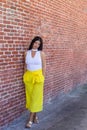 Trendy thoughtful woman leaning against a wall